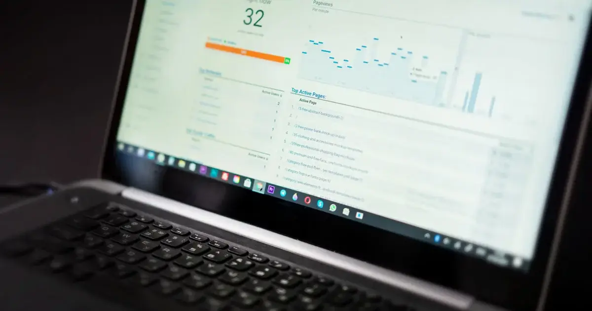 Laptop displaying a website analytics dashboard with traffic metrics, pageviews, performance charts, and active page data.